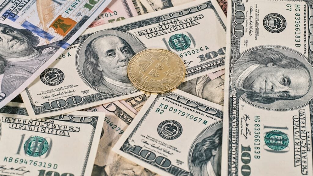 Bitcoin coin on US dollar bills representing currency and inflation concepts.