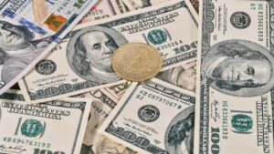 Bitcoin coin on US dollar bills representing currency and inflation concepts.