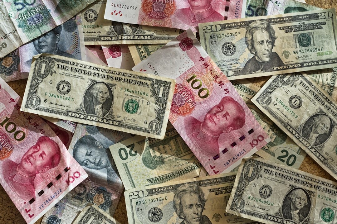 Various US dollar and Chinese yuan banknotes scattered on a surface.