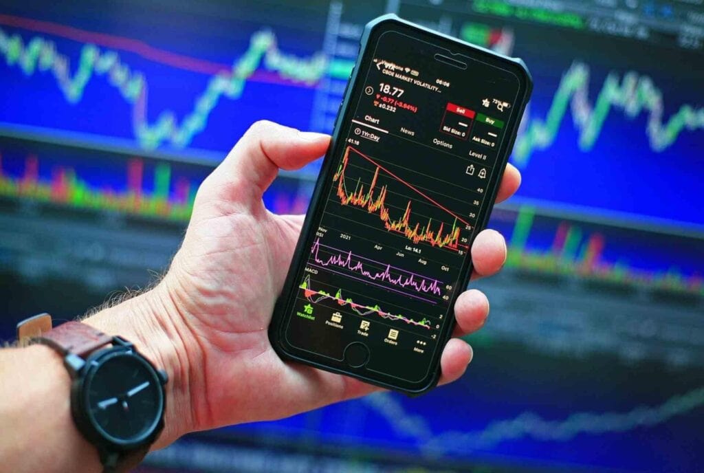 Smartphone displaying financial trading app with stock charts and data.
