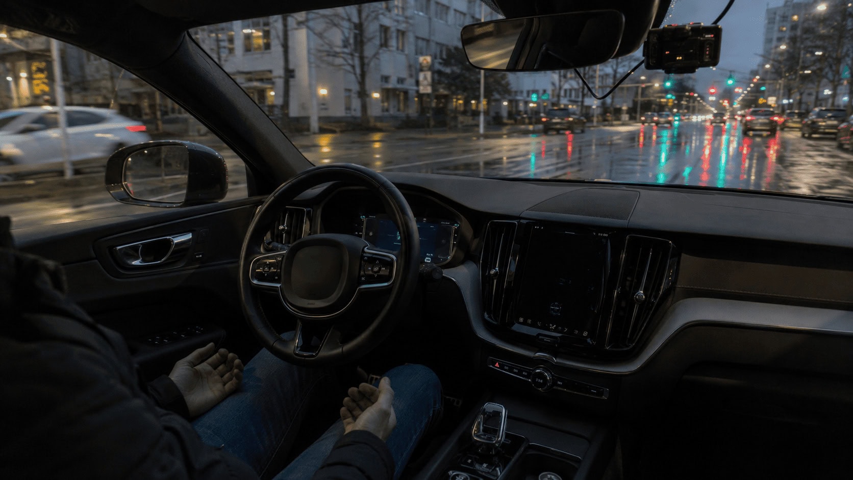 Driver with hands off the wheel as a self-driving system steers through a city street.
