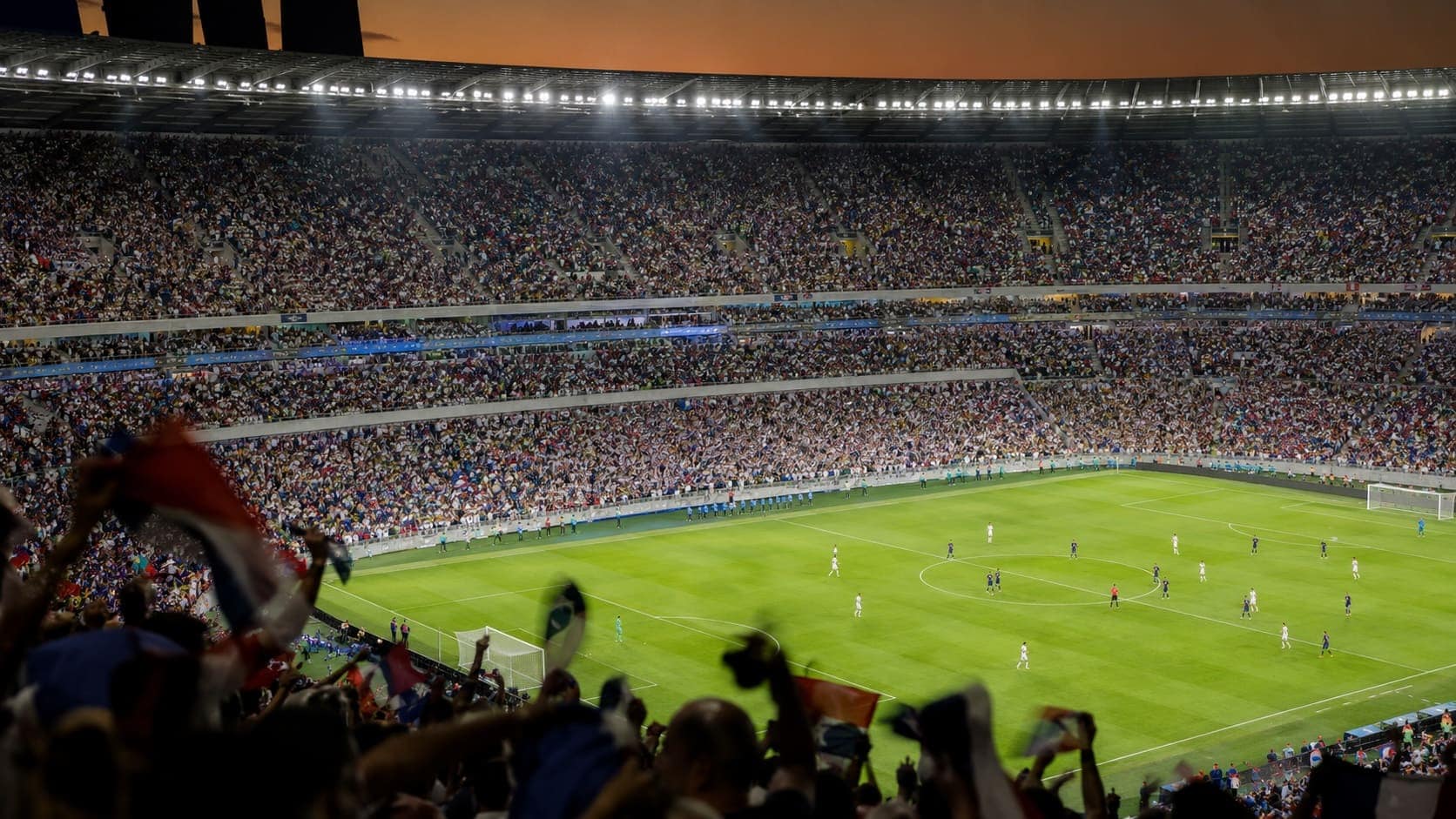 Floodlit World Cup 2026 stadium packed with fans during an opening match, viewed from an elevated angle.