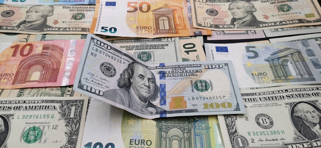Various US dollar and Euro banknotes spread out on a surface.