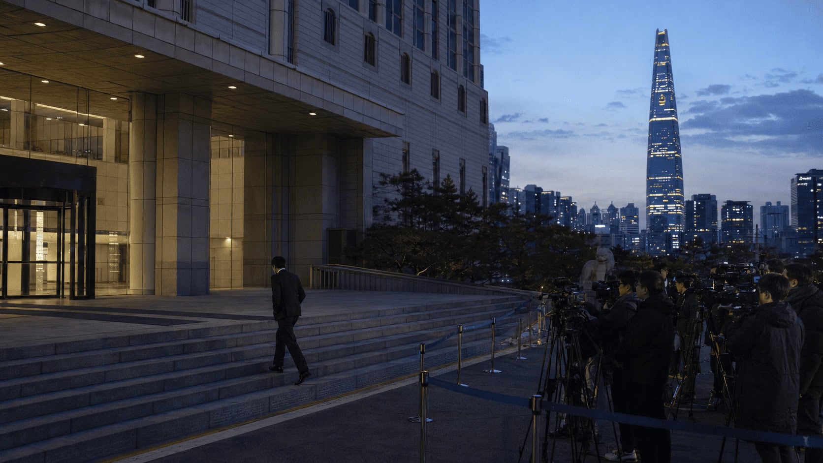 SK Group chairman Chey Tae-won leaving a Seoul high court past waiting press after the $644 million divorce ruling, SK corporate tower in the skyline behind.