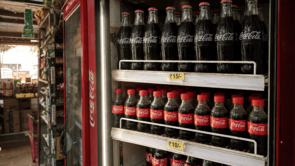 Small-format Coca-Cola bottles stocked in a convenience store cooler in India