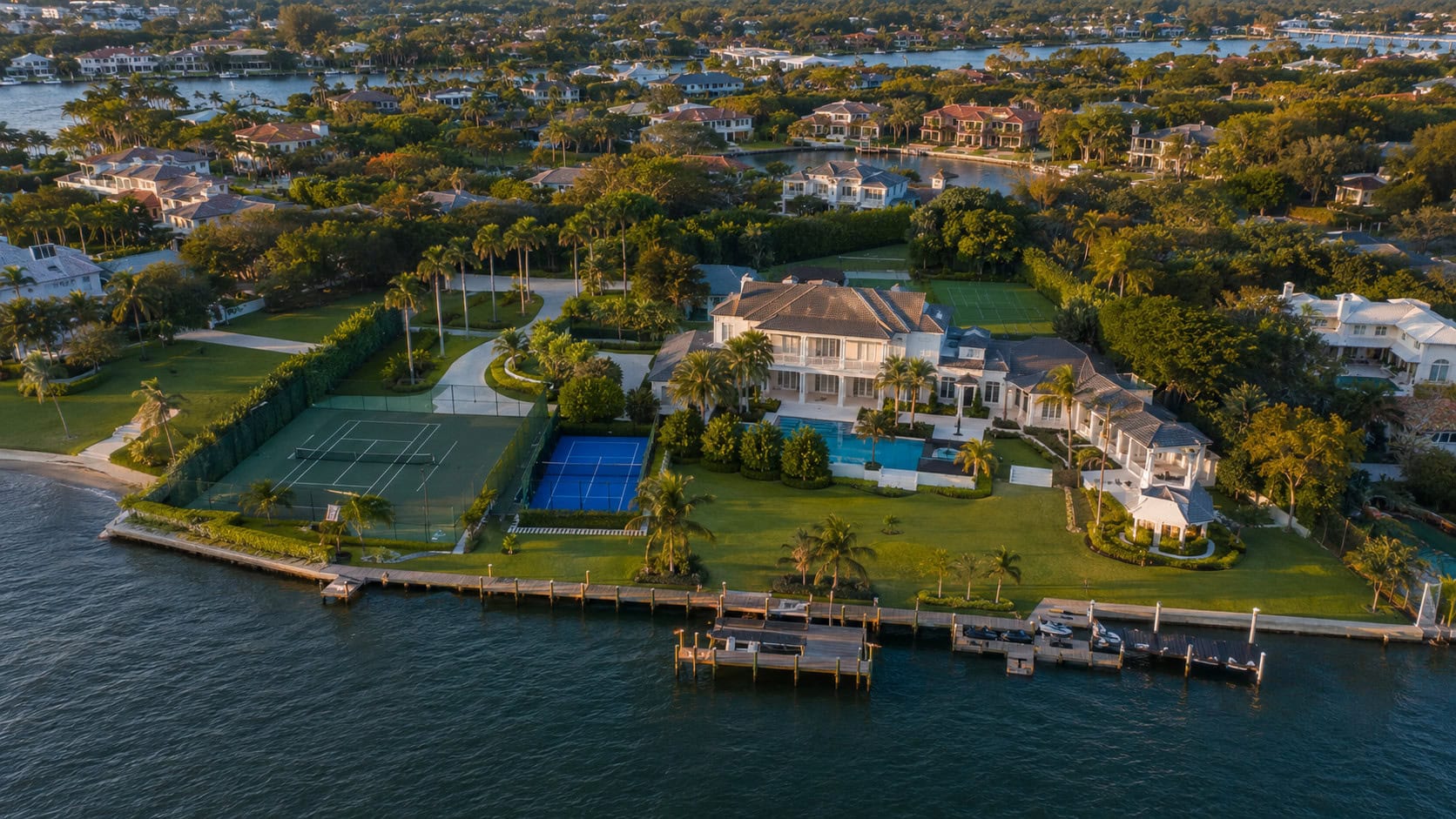 Aerial view of a large waterfront compound formed by combining several neighboring properties into a single private estate.