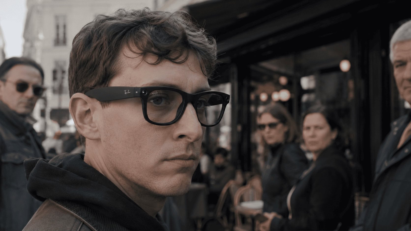 Person wearing Ray-Ban Meta glasses in public with the camera recording light visible