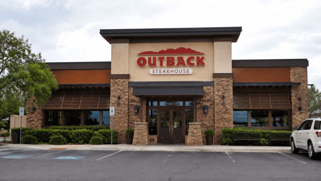 Outback Steakhouse restaurant exterior with illuminated sign at dusk.