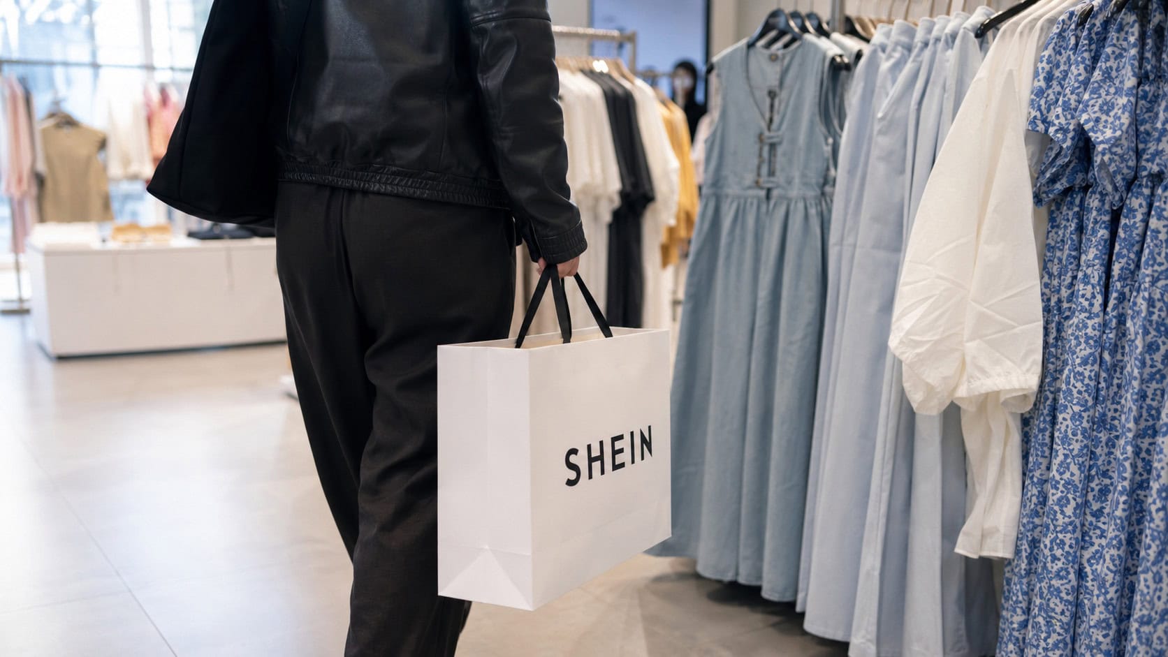 Shopper carrying a Shein bag, illustrating the fast-fashion retailer's Hong Kong IPO approval and reduced valuation