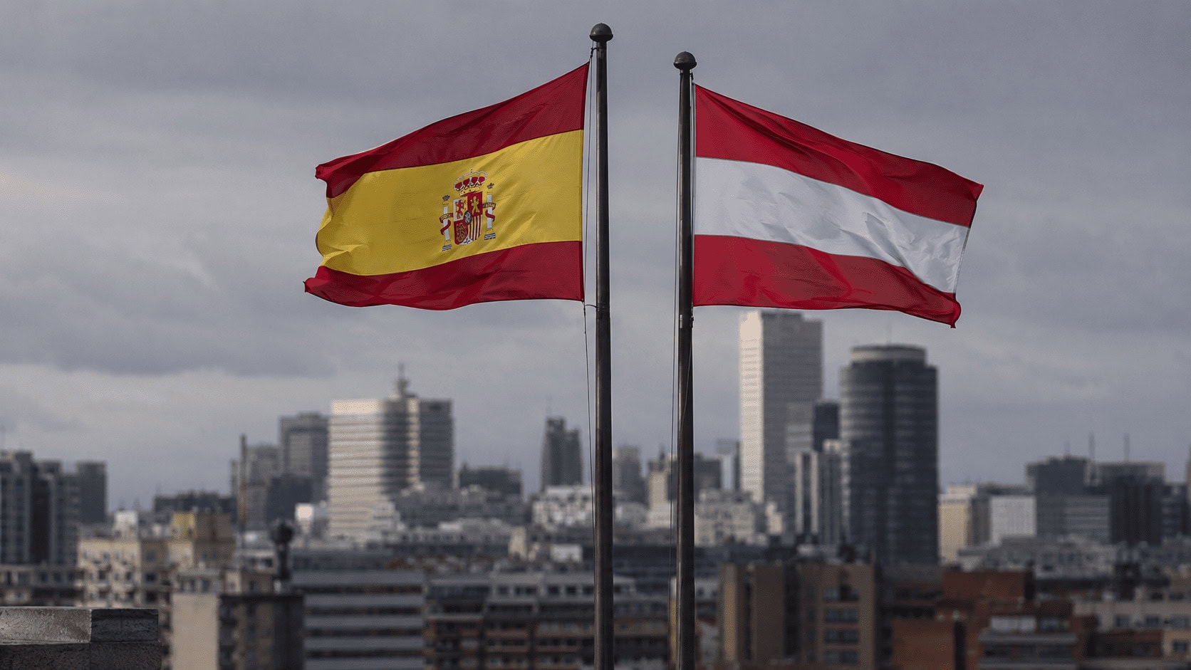 Spain vs Austria economic comparison for the 2026 World Cup, split-field illustration with a soccer ball on the center line.