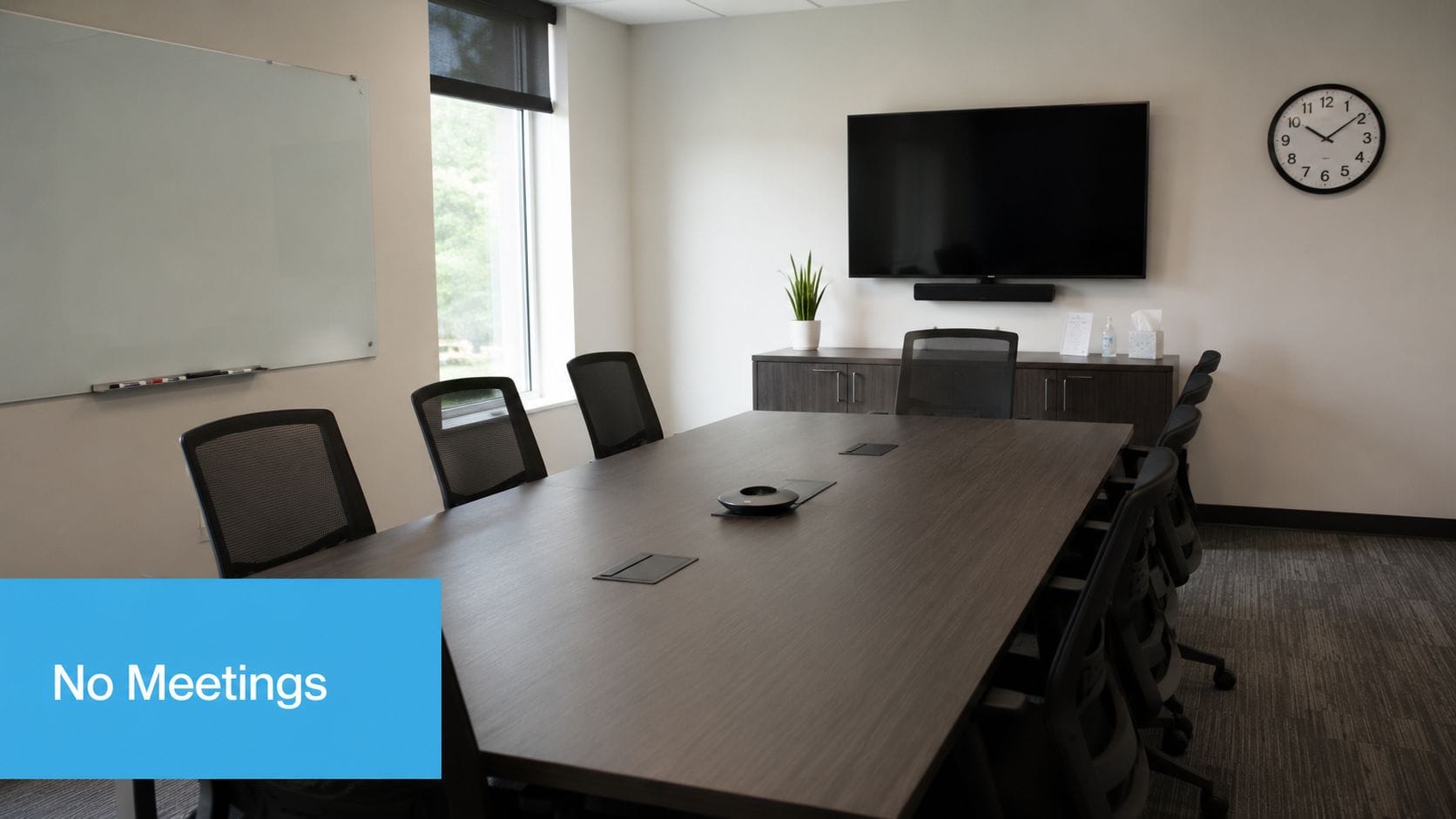 Modern conference room with empty table and chairs, no meetings scheduled.