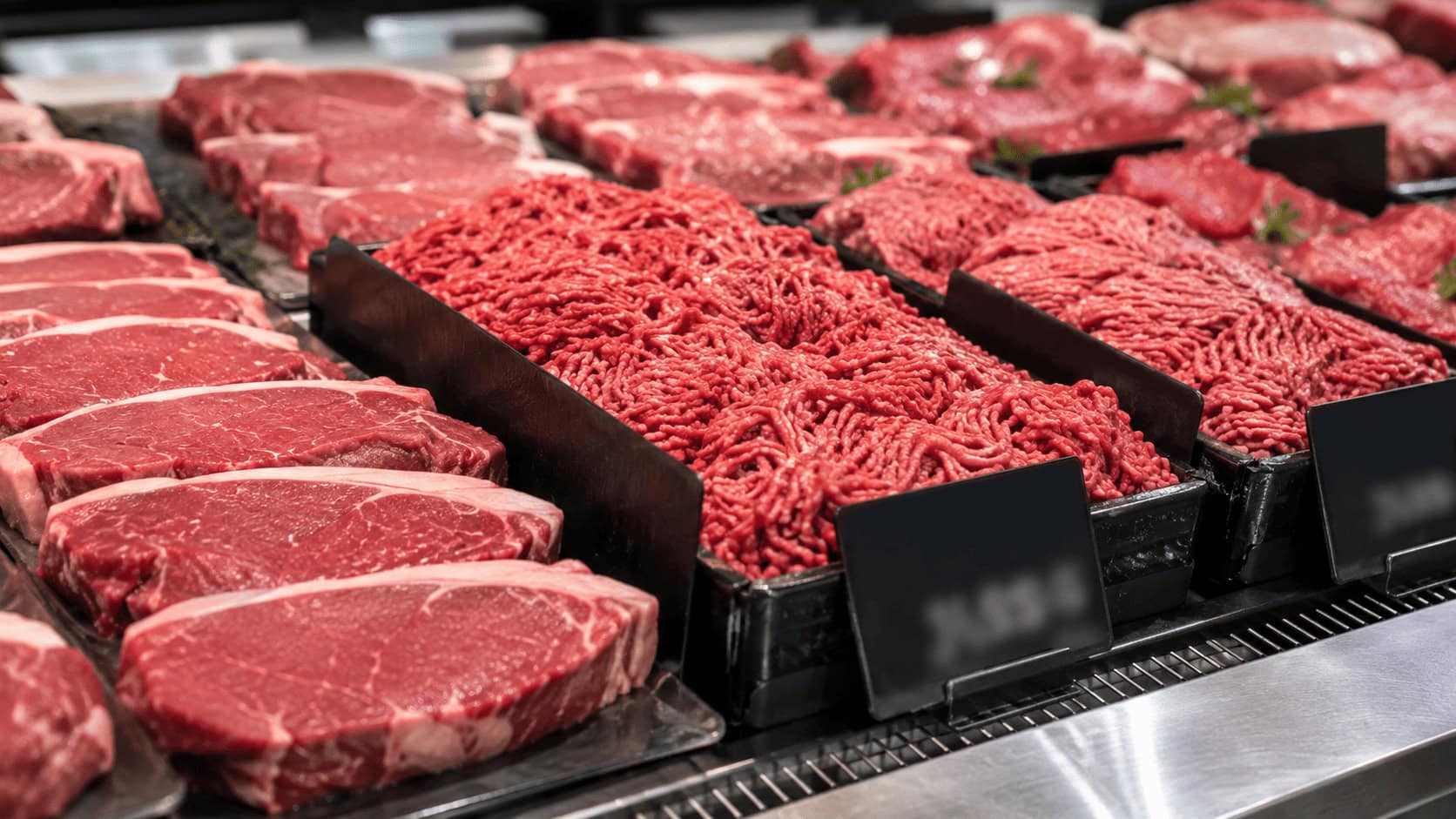 "Packages of fresh ground beef and steaks priced at a US supermarket meat counter