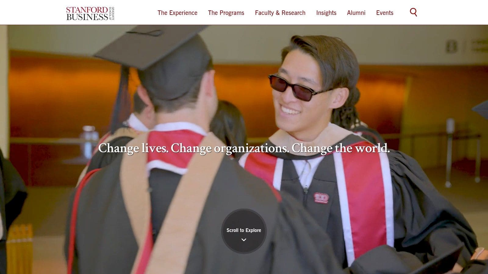 Graduates in caps and gowns celebrating at Stanford Business School.