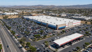 Aerial view of a Costco warehouse with its rooftop, parking lot and adjacent gas station filling the frame