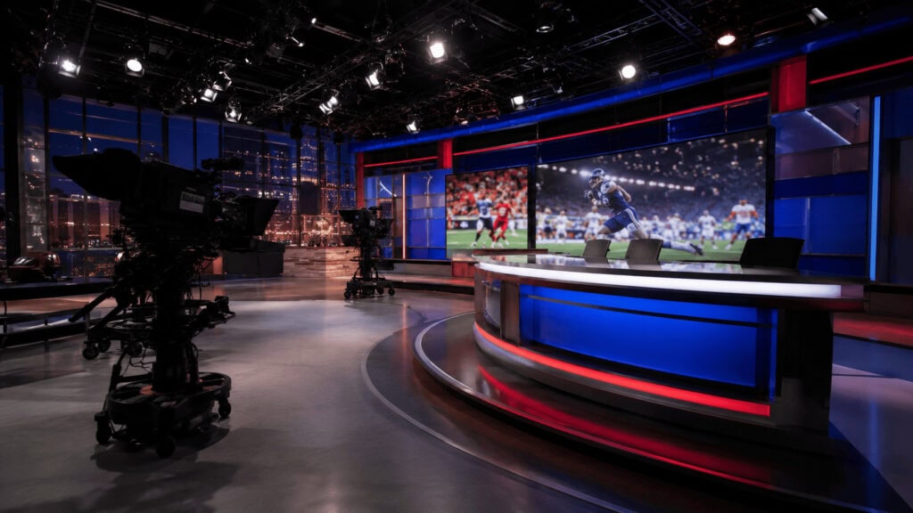 Empty sports television broadcast studio with anchor desk, video wall and studio cameras, representing ESPN's Bristol, Connecticut operation.