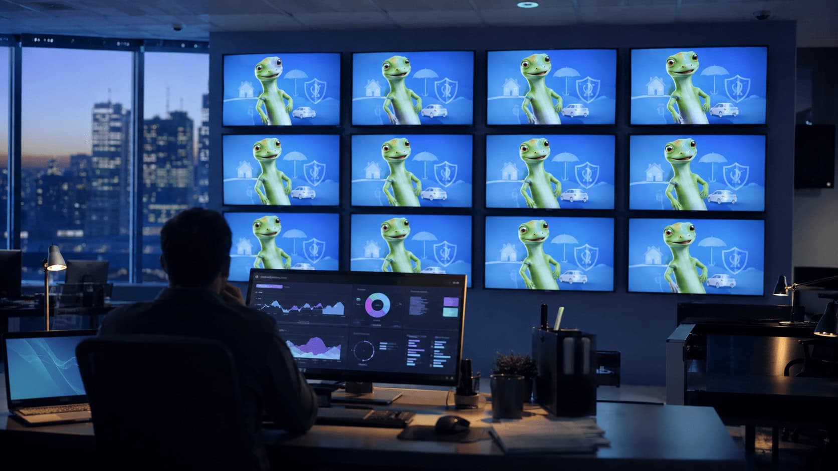 GEICO advertising running on a bank of television screens in a media buying office