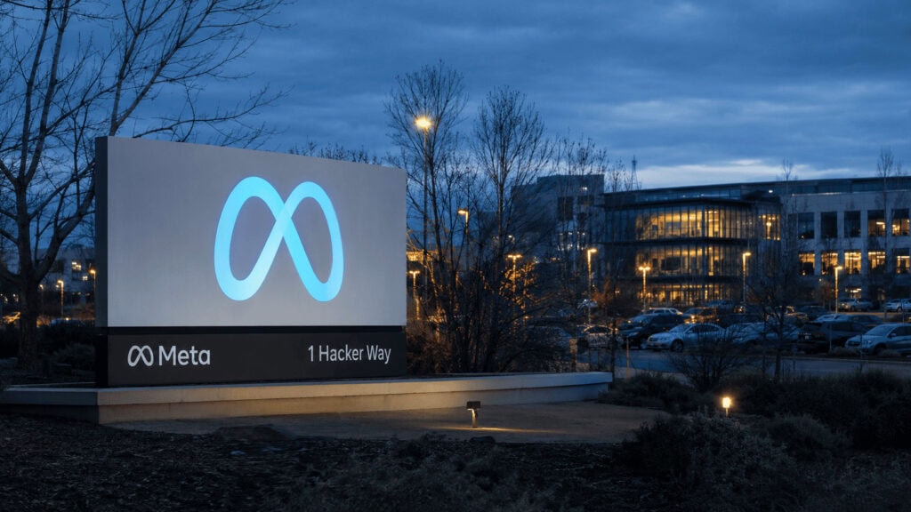 Meta's Menlo Park headquarters sign at dusk with the company logo lit against an overcast sky
