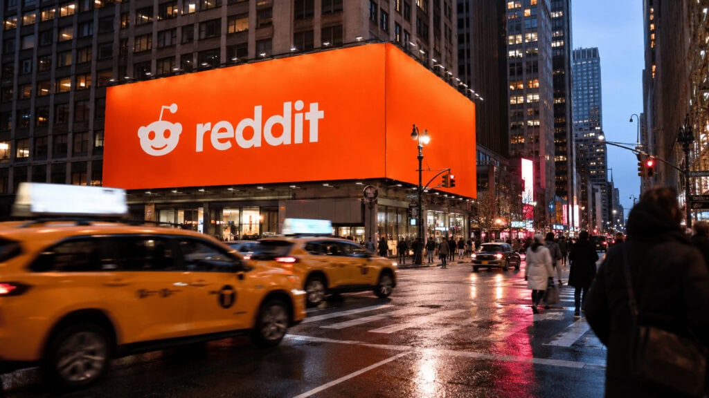 Reddit marketing strategy: a Reddit-branded billboard lit up over a New York City intersection at dusk.