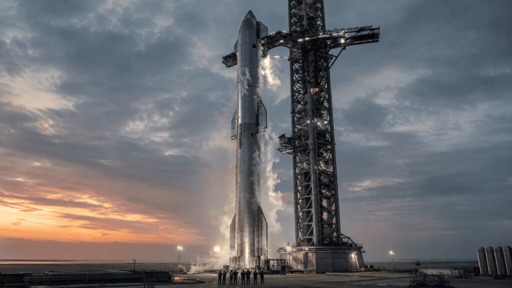 A towering stainless-steel Starship rocket venting vapor on a coastal launch pad at dusk, dwarfing the engineers at its base.