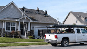 Roofing crew working on a suburban house roof, the highest-rated workers' compensation job class in most US states