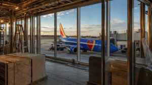 Southwest Airlines Boeing 737 at a jet bridge with an airport terminal construction hoarding in the foreground