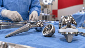 Hip and knee replacement implants on a surgical tray in an operating room, as J&J weighs spinning off its DePuy Synthes orthopedics business.
